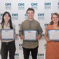 Three students hold a certificate