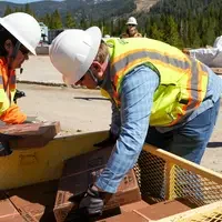Student interns picking up drill core from crate