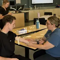 Students sitting at desk and practicing IV exercises 