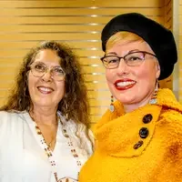 Two people stand together, smiling