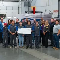 Large group of people hold a check in Automotive lab
