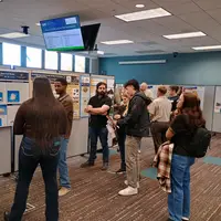 People gather around various posters and presentations