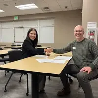 Roxana shaking hands with Adult Education Director, Jac Webb