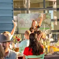 People sitting at tables, raising hands