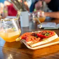 Glass of whiskey sour and bread with tomatoes