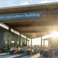 Groups of people sitting underneath Simplot Agriculture Building awning