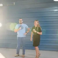 Two people standing in front of blue wall