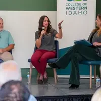 Three people sit in chairs, talking