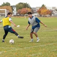 Two soccer players bouncing a soccer ball