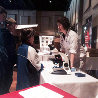 Students surrounding a table learning about programs