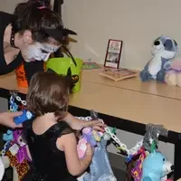 UROC student helping a little girl play a game.