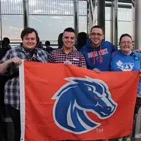 Yeates with fellow Boise State students holding a Boise State flag