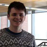 Close up of smiling male student wearing a gray patterned sweater