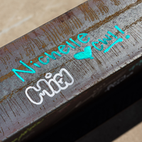 A handwritten name on a metal construction beam.