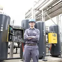 Student standing in front of machinery