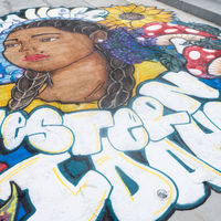 A floral mural painted in a graffiti syle on a bridge.