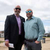 Two people smile as they look into the camera for a portrait.