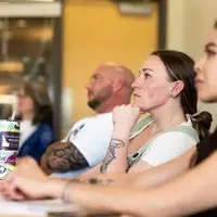 A member of the community listens to a mini-talk being presented at CWI 2024 Connections Project.