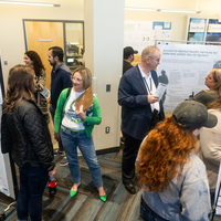Many students and members of the community stand in front of research posters displayed during the 2024 CWI Connections Project.