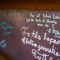 A metal construction beam with signatures.