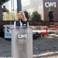 A speaker addresses and audience at a construction site.