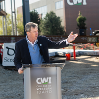 A speaker addresses and audience at a construction site.
