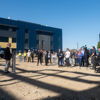 A speaker addresses and audience at a construction site.