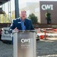 A speaker addresses and audience at a construction site.