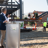 A speaker addresses and audience at a construction site.