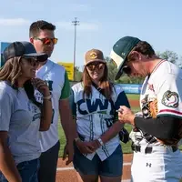 Fans enjoy a night at a baseball game.