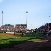 Fans enjoy a night at a baseball game.