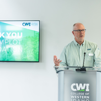 Donors and College representatives attend a sign unveiling at a new building on campus.
