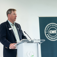 Donors and College representatives attend a sign unveiling at a new building on campus.