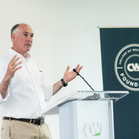 Donors and College representatives attend a sign unveiling at a new building on campus.