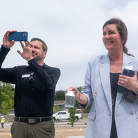 Donors and College representatives attend a sign unveiling at a new building on campus.