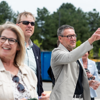 Donors and College representatives attend a sign unveiling at a new building on campus.