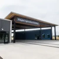 Donors and College representatives attend a sign unveiling at a new building on campus.