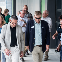 Donors and College representatives attend a sign unveiling at a new building on campus.