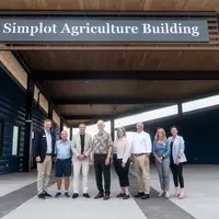 Donors and College representatives attend a sign unveiling at a new building on campus.