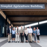 Donors and College representatives attend a sign unveiling at a new building on campus.
