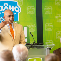 A speaker stands at a podium addressing an audience.