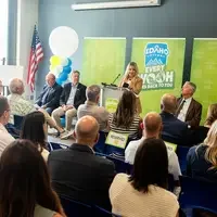 A speaker stands at a podium addressing an audience.