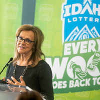 A speaker stands at a podium addressing an audience.