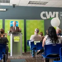 A speaker stands at a podium addressing an audience.
