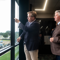 A group of people are led on a guided tour of a new college campus building.