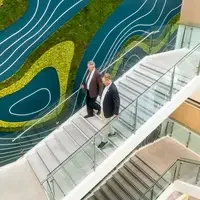 A group of people are led on a guided tour of a new college campus building.