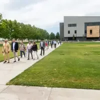A group of people are led on a guided tour of a new college campus building.