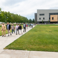 A group of people are led on a guided tour of a new college campus building.