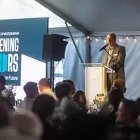 A speaker addresses an audience during a benefit dinner.