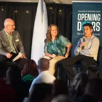 Panel speakers converse while an audience listens.